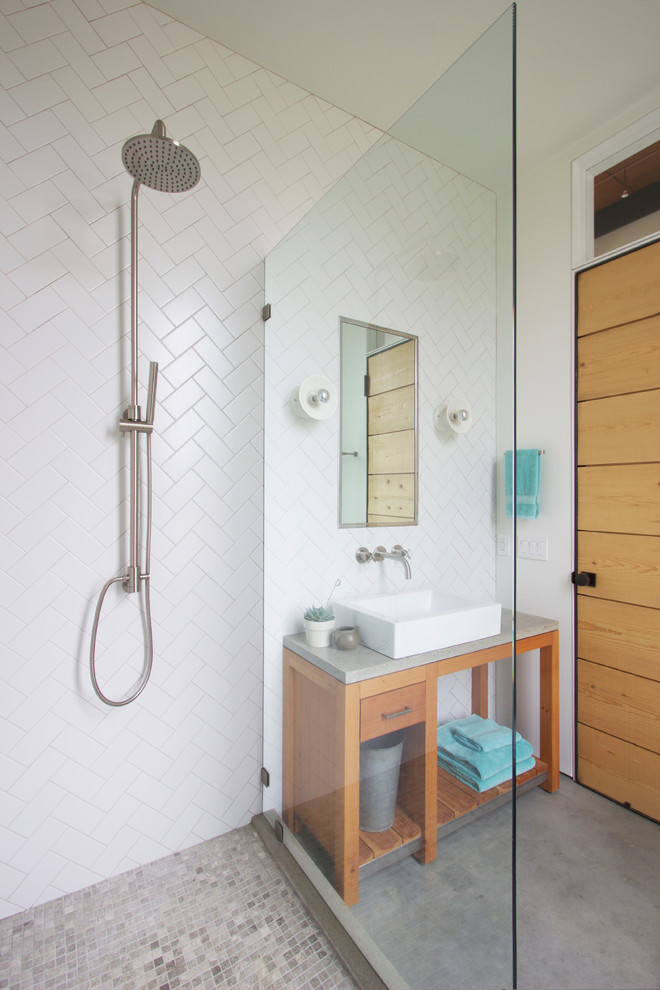 Inspiration for a small beach style bathroom in Providence with a vessel sink, open cabinets, medium wood cabinets, concrete benchtops, an open shower, white tile, ceramic tile, white walls, concrete floors and an open shower.