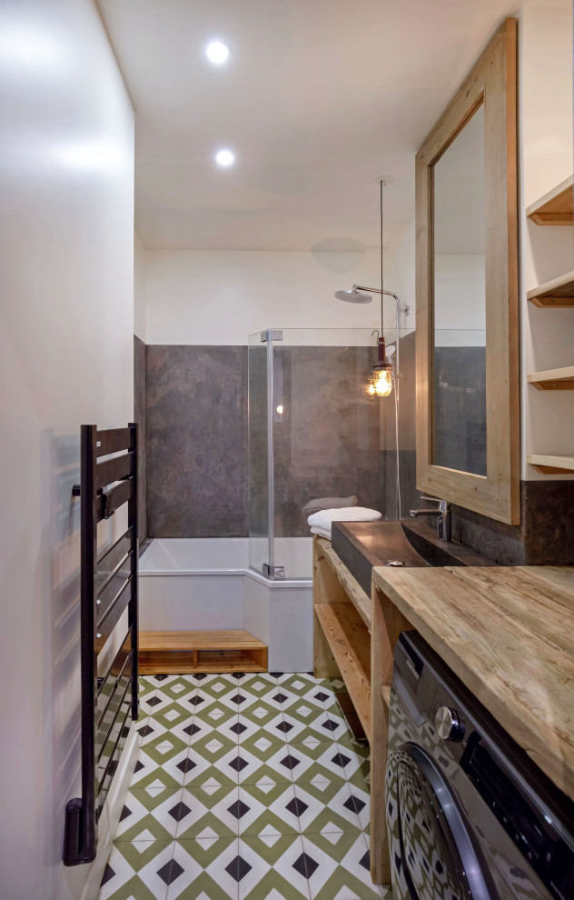 Foto på ett litet industriellt en-suite badrum, med en dusch/badkar-kombination, stenhäll, cementgolv, ett undermonterat badkar, ett nedsänkt handfat och träbänkskiva