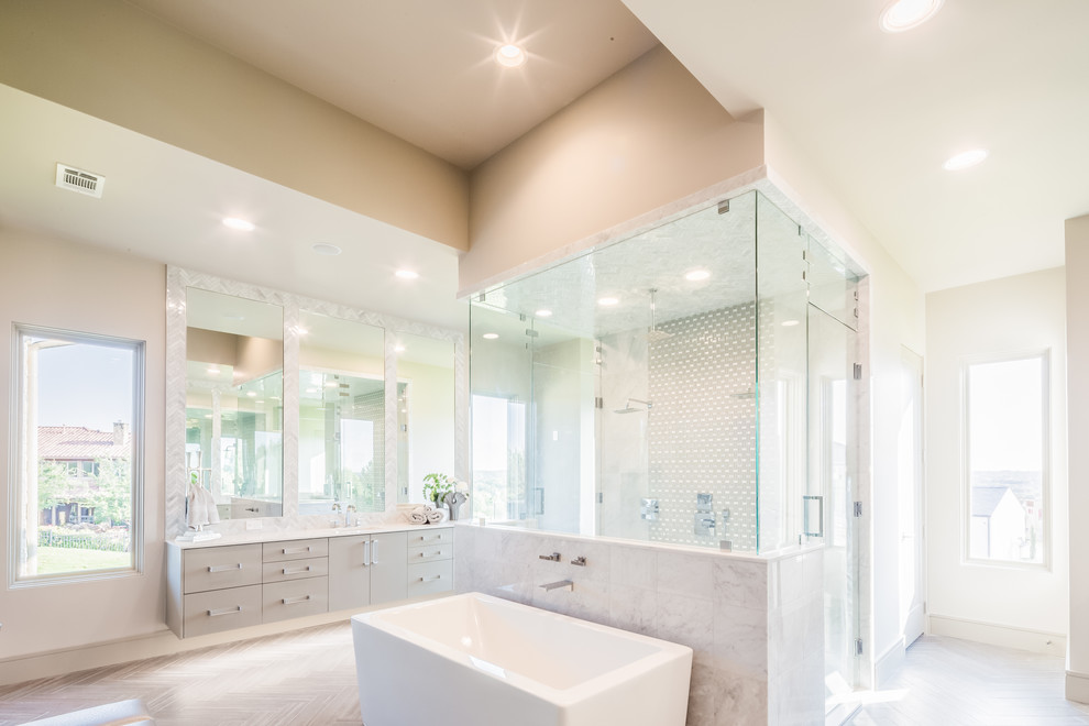 Expansive transitional master bathroom in Dallas with flat-panel cabinets, grey cabinets, a freestanding tub, a double shower, a two-piece toilet, gray tile, marble, grey walls, ceramic floors, an undermount sink, engineered quartz benchtops, brown floor, a hinged shower door and white benchtops.