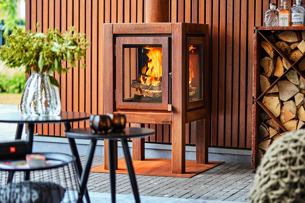 Large scandinavian patio in Amsterdam with with fireplace and a pergola.