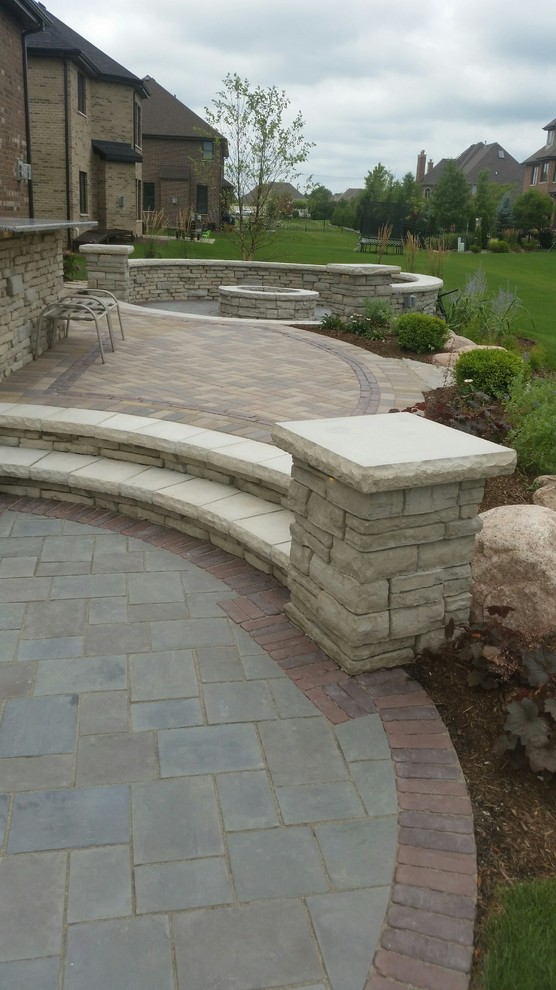 Photo of a large contemporary backyard patio in Chicago with an outdoor kitchen, concrete pavers and no cover.