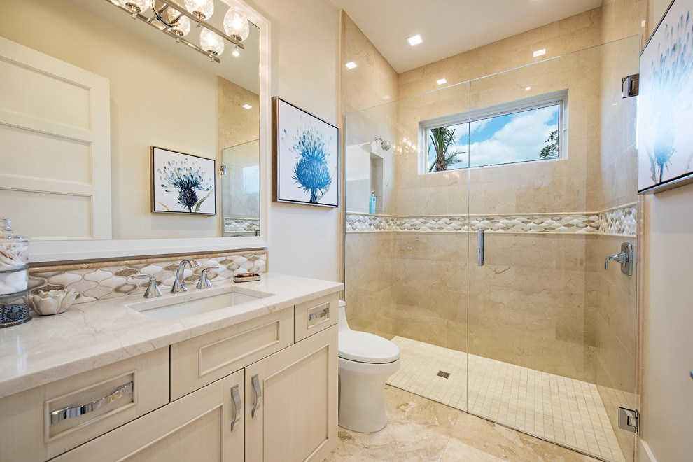 Photo of a mid-sized transitional kids bathroom in Miami with raised-panel cabinets, beige cabinets, an open shower, a one-piece toilet, beige tile, stone tile, beige walls, marble floors, an undermount sink and quartzite benchtops.