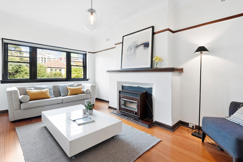 Mid-sized contemporary open concept living room in Melbourne with white walls, medium hardwood floors, a standard fireplace, a tile fireplace surround and brown floor.