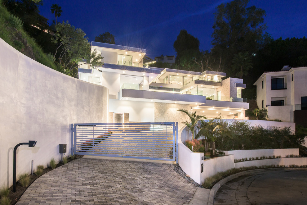 Photo of a contemporary three-storey stucco white house exterior in Los Angeles with a flat roof.