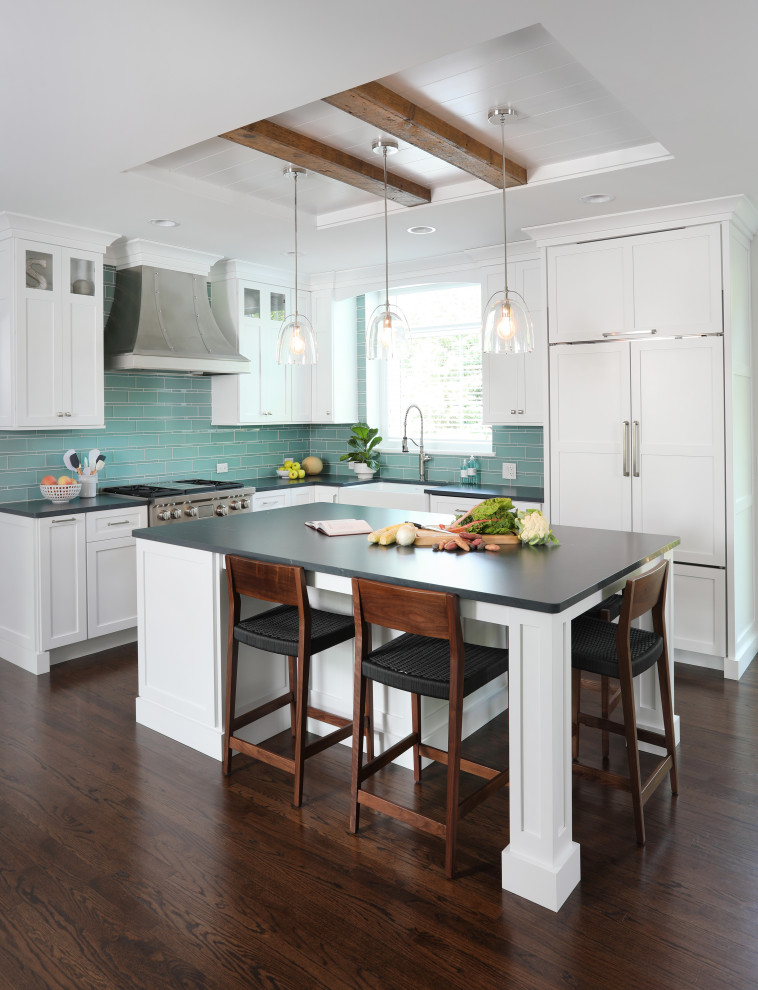 Inspiration for a transitional u-shaped dark wood floor and brown floor kitchen pantry remodel in Chicago with a farmhouse sink, white cabinets, soapstone countertops, blue backsplash, glass tile backsplash, paneled appliances, an island and black countertops