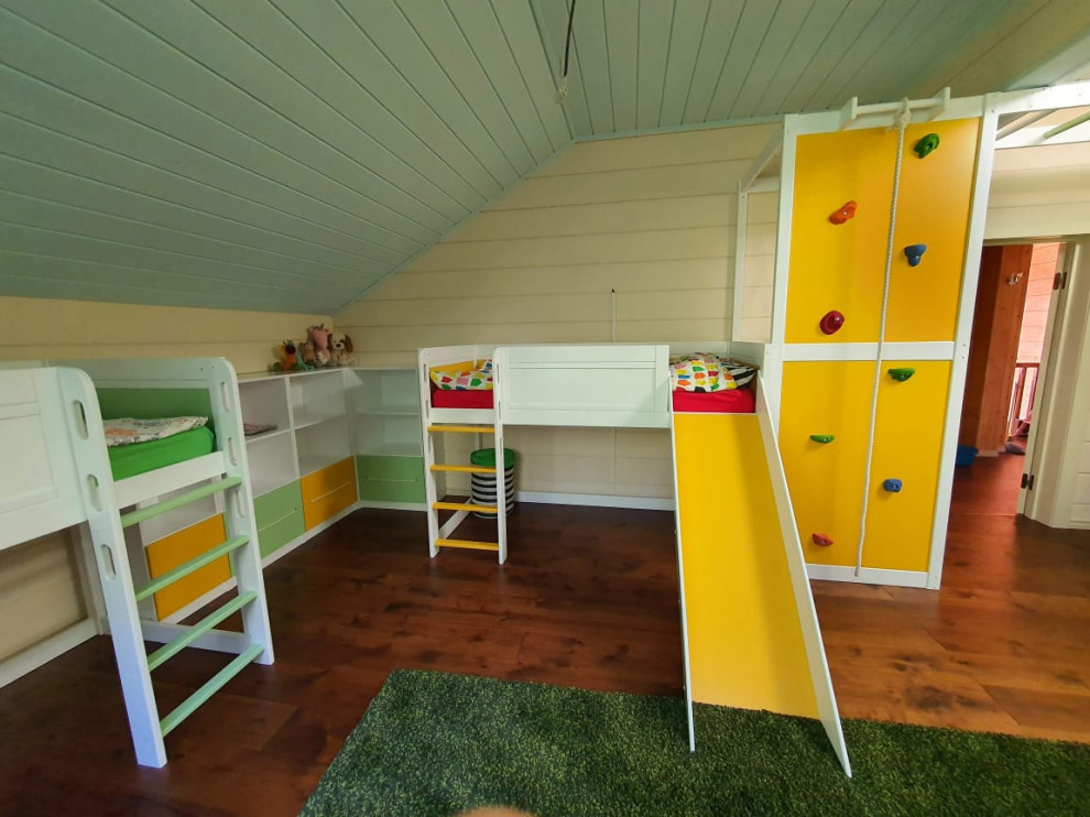 На фото: большая нейтральная детская с игровой в скандинавском стиле с желтыми стенами, темным паркетным полом, коричневым полом, деревянным потолком и стенами из вагонки для ребенка от 4 до 10 лет, двоих детей с
