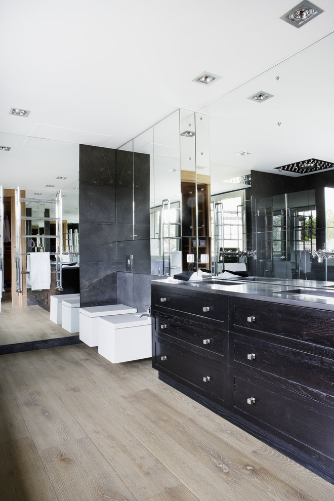 Contemporary bathroom in Madrid with an undermount sink, dark wood cabinets, marble benchtops, a wall-mount toilet, black tile, stone slab and shaker cabinets.