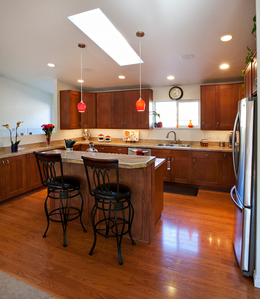 Open concept kitchen - mid-sized transitional l-shaped medium tone wood floor open concept kitchen idea with a drop-in sink, shaker cabinets, medium tone wood cabinets, granite countertops, stainless steel appliances and an island
