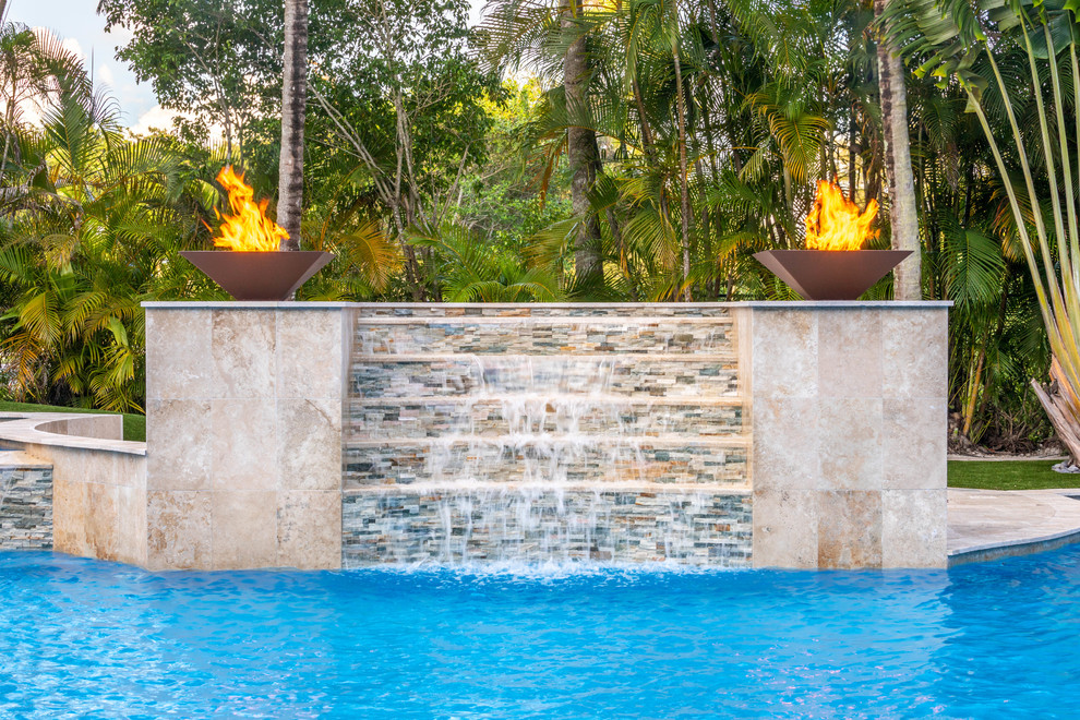 Design ideas for an expansive modern backyard custom-shaped infinity pool in Miami with a water feature and tile.