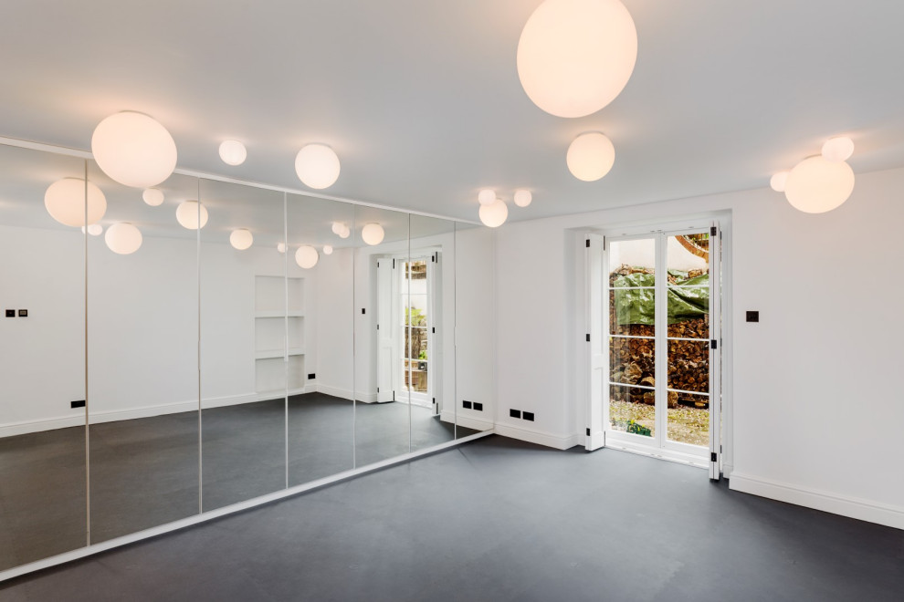 Inspiration for a large transitional multipurpose gym in Devon with white walls and grey floor.