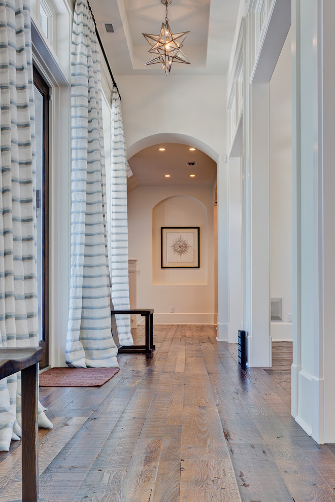 This is an example of a transitional hallway in Other with white walls and medium hardwood floors.