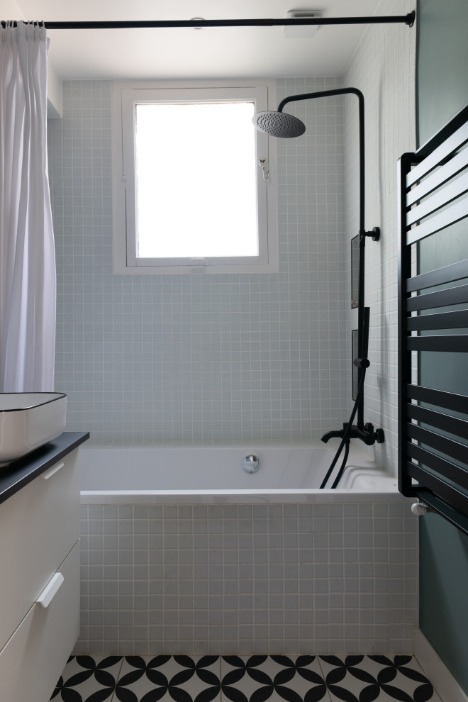 Идея дизайна: ванная комната среднего размера в стиле фьюжн с полновстраиваемой ванной, белой плиткой, керамогранитной плиткой, синими стенами, полом из мозаичной плитки и черной столешницей