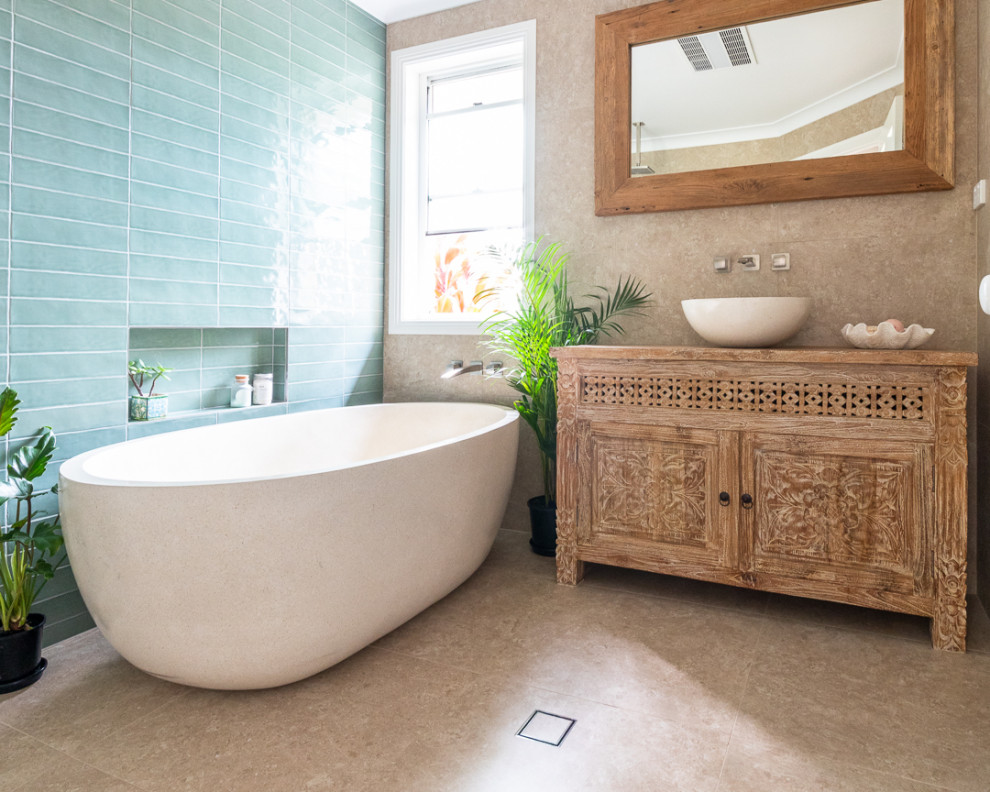 Example of a mid-sized asian master green tile and ceramic tile porcelain tile, beige floor and single-sink bathroom design in Other with furniture-like cabinets, light wood cabinets, beige walls, a vessel sink, wood countertops, a niche and a freestanding vanity