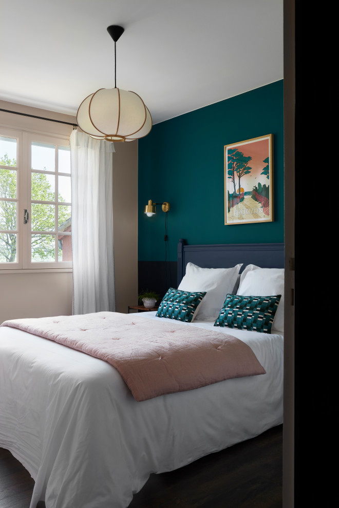 Eclectic bedroom in Nantes with blue walls and dark hardwood floors.