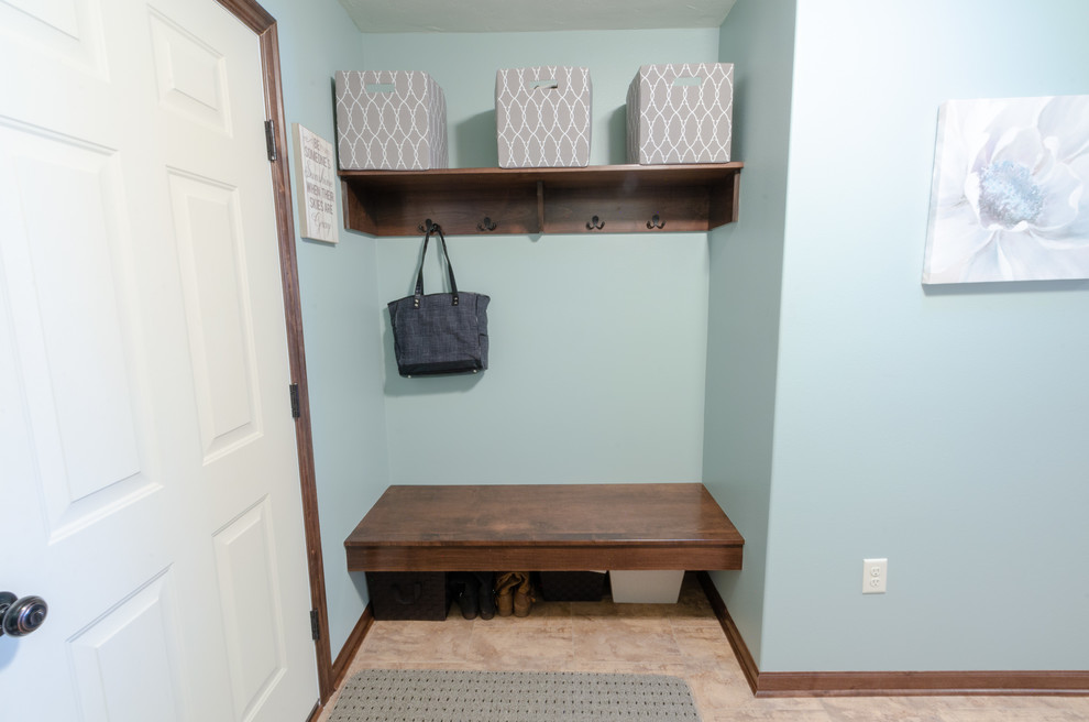 Traditional dedicated laundry room in Milwaukee with brown cabinets, blue walls, ceramic floors, a side-by-side washer and dryer and grey floor.