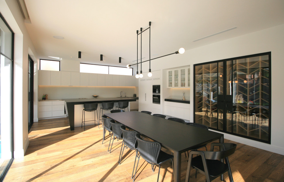 Design ideas for a large contemporary open plan dining in Melbourne with white walls and medium hardwood floors.
