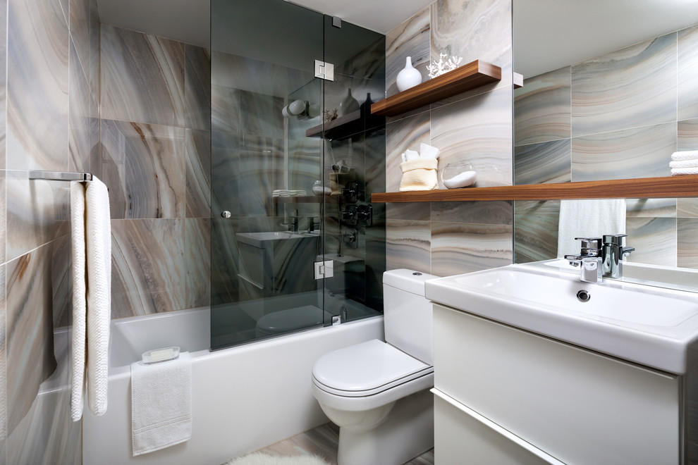 Design ideas for a mid-sized contemporary bathroom in Toronto with an integrated sink, flat-panel cabinets, white cabinets, an alcove tub, a shower/bathtub combo, multi-coloured tile and a two-piece toilet.