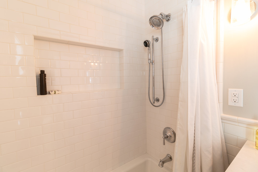 Photo of a mid-sized traditional master bathroom in Minneapolis with recessed-panel cabinets, grey cabinets, an alcove tub, an alcove shower, a one-piece toilet, white tile, subway tile, grey walls, porcelain floors, an undermount sink, engineered quartz benchtops, multi-coloured floor, a shower curtain and white benchtops.