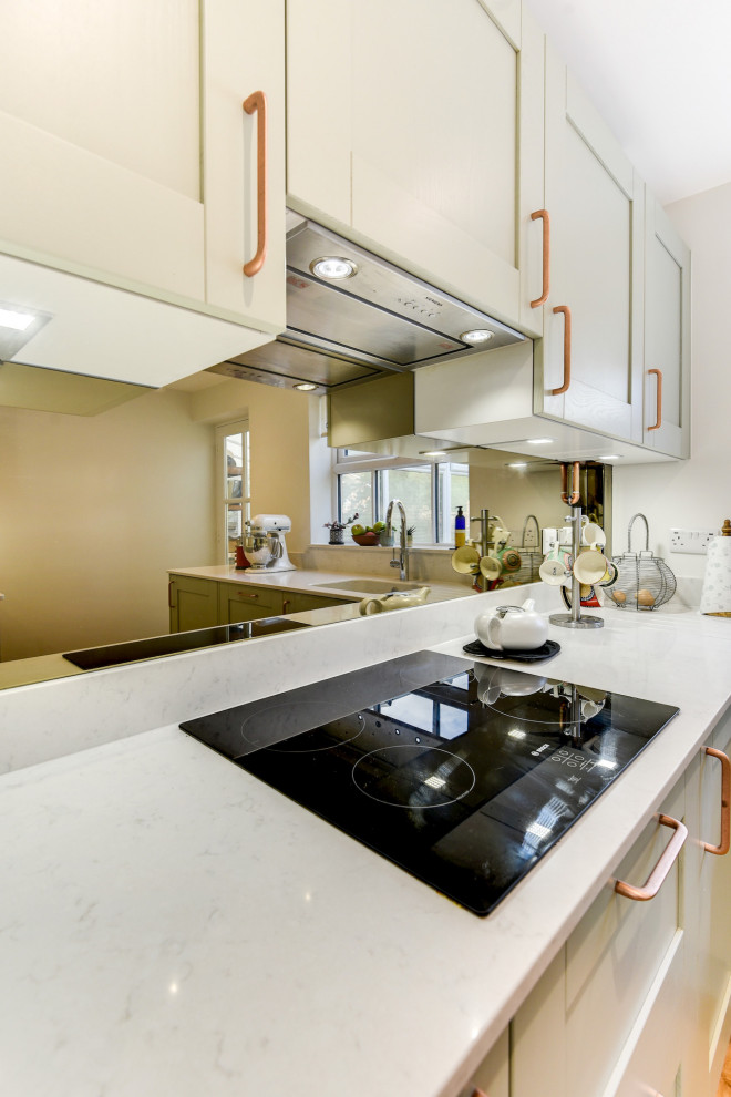 Exempel på ett mellanstort modernt vit vitt kök, med en undermonterad diskho, skåp i shakerstil, gröna skåp, bänkskiva i kvartsit, stänkskydd med metallisk yta, glaspanel som stänkskydd, integrerade vitvaror, ljust trägolv, en köksö och brunt golv