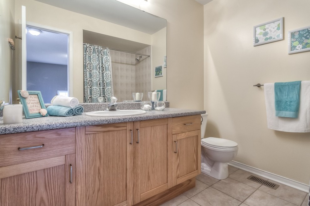 Mid-sized transitional 3/4 brown tile and ceramic tile bathroom photo in Toronto with beaded inset cabinets, distressed cabinets, laminate countertops and brown walls