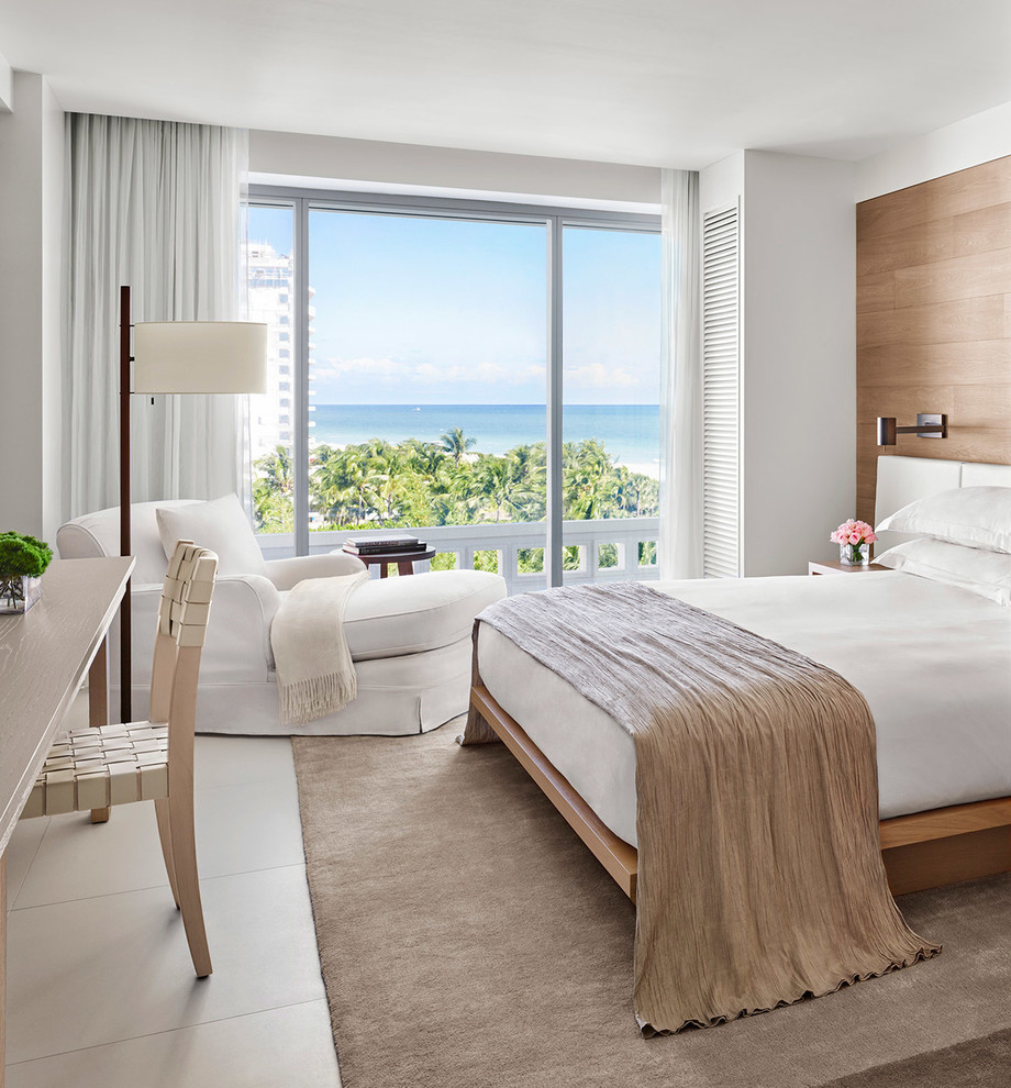 Design ideas for a large beach style master bedroom in Miami with white walls and white floor.