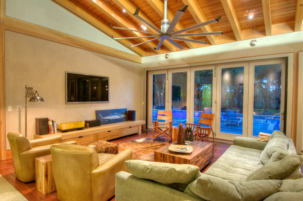 Photo of a mid-sized contemporary open concept living room in Other with no fireplace, a wall-mounted tv, beige walls, medium hardwood floors and exposed beam.