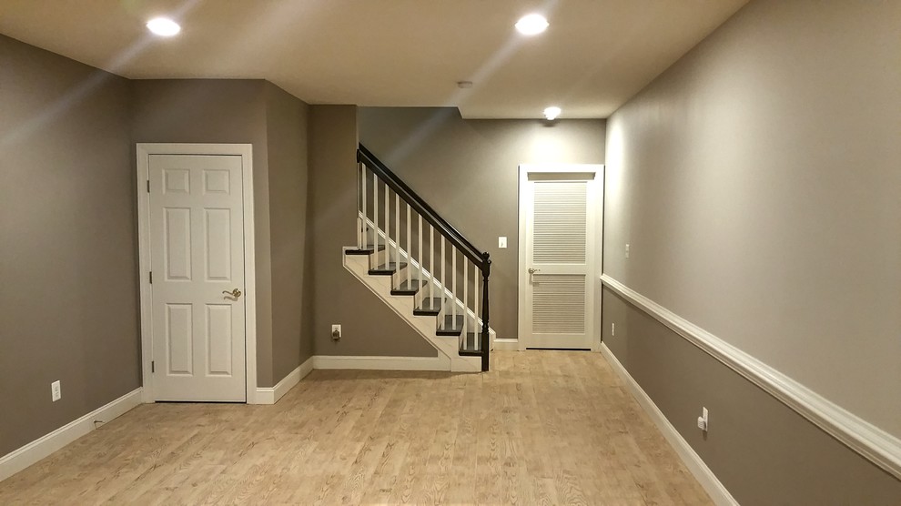 Inspiration for a large contemporary walk-out basement in DC Metro with grey walls, porcelain floors, a standard fireplace and a brick fireplace surround.