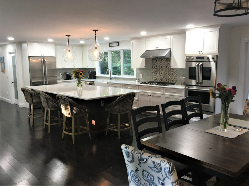 Example of a huge transitional l-shaped dark wood floor and brown floor eat-in kitchen design in Boston with a farmhouse sink, shaker cabinets, white cabinets, quartz countertops, gray backsplash, subway tile backsplash, stainless steel appliances, an island and white countertops
