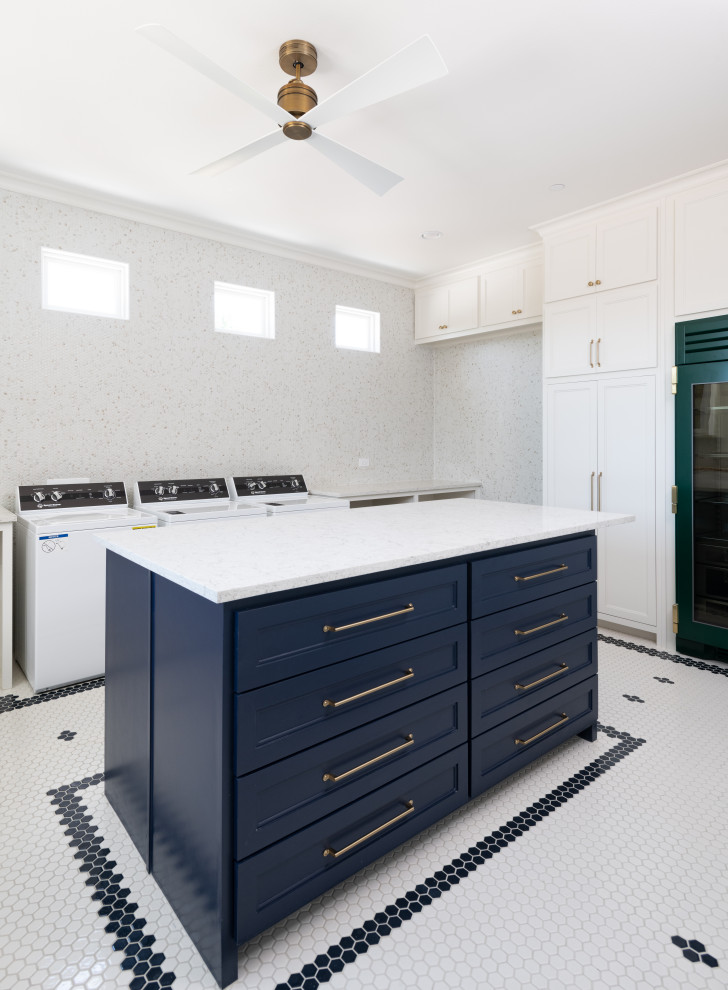 This is an example of an expansive country u-shaped dedicated laundry room in Dallas with a farmhouse sink, shaker cabinets, white cabinets, quartz benchtops, beige splashback, mosaic tile splashback, white walls, ceramic floors, a side-by-side washer and dryer, multi-coloured floor and multi-coloured benchtop.