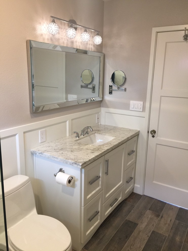 Photo of a small beach style master bathroom in San Luis Obispo with shaker cabinets, white cabinets, an open shower, a one-piece toilet, multi-coloured tile, ceramic tile, grey walls, ceramic floors, an undermount sink, granite benchtops, multi-coloured floor, a hinged shower door and multi-coloured benchtops.