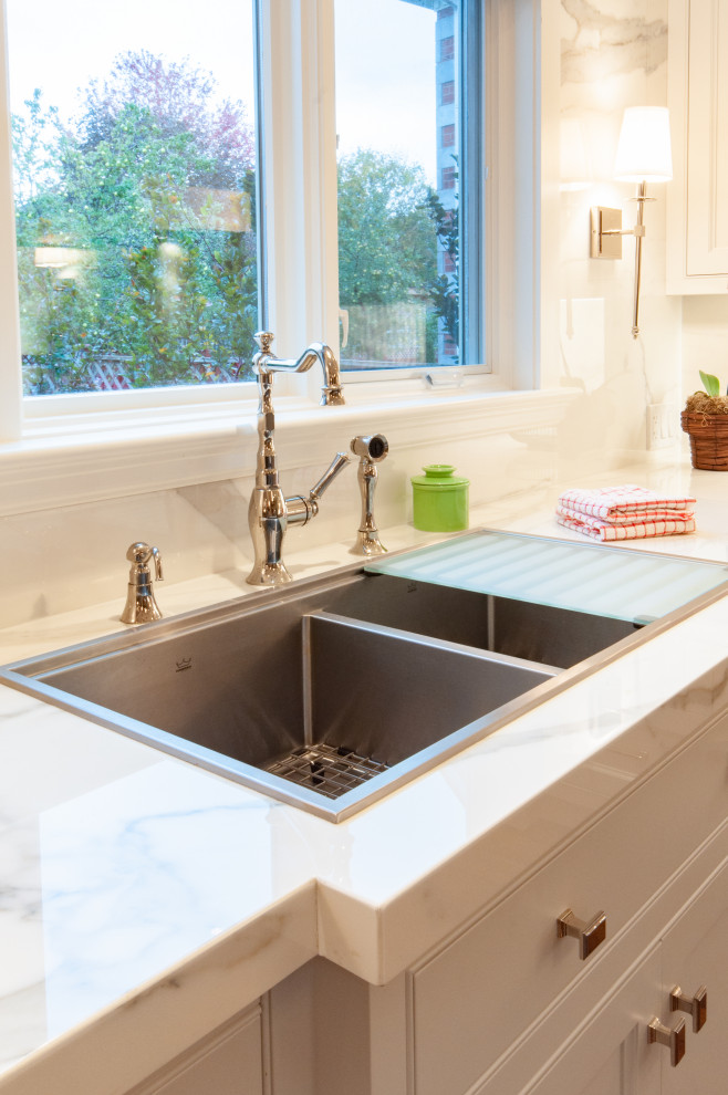 Large elegant u-shaped dark wood floor and brown floor kitchen pantry photo in Toronto with a drop-in sink, beaded inset cabinets, white cabinets, marble countertops, white backsplash, marble backsplash, stainless steel appliances, an island and white countertops