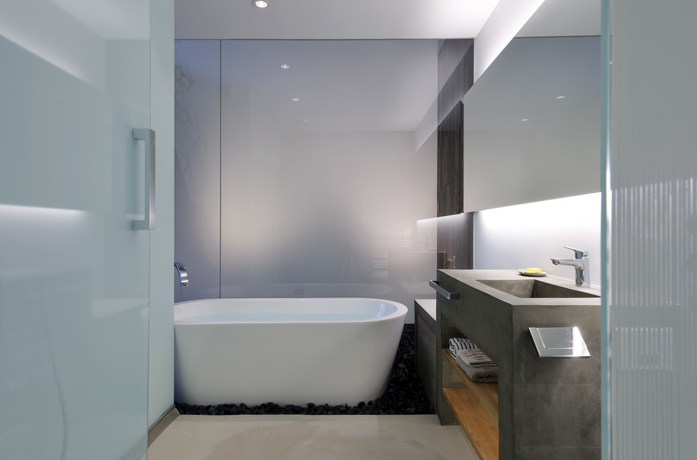 Industrial bathroom in Kyoto with open cabinets, a freestanding tub, white walls and grey floor.