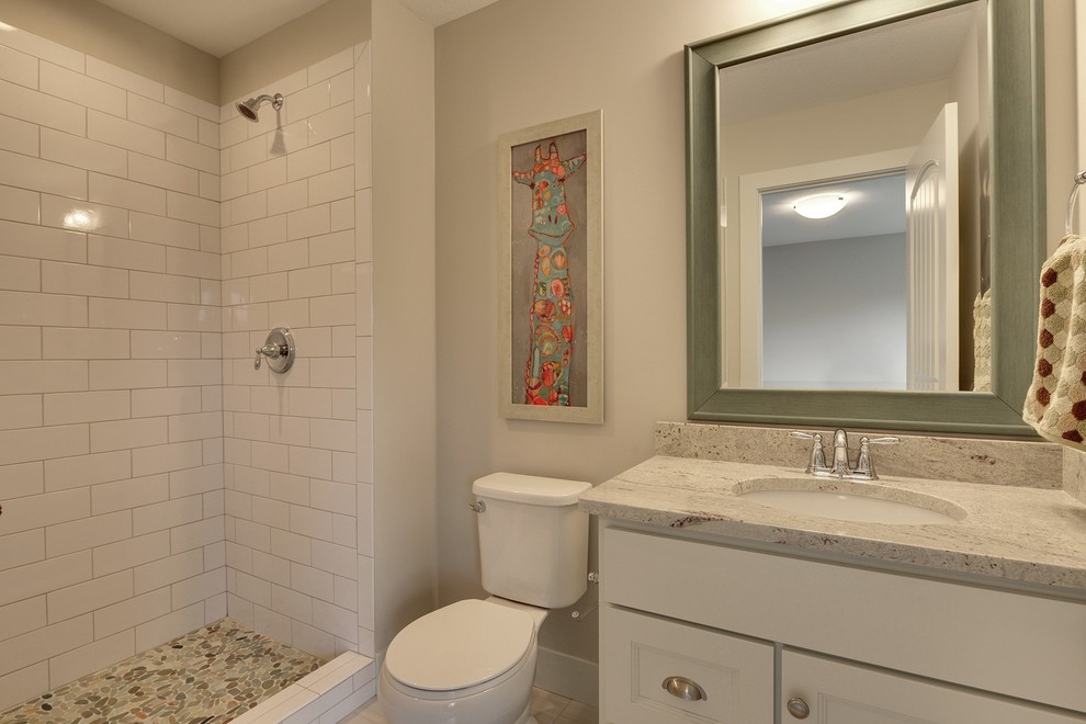 Photo of a large transitional master bathroom in Minneapolis with recessed-panel cabinets, white cabinets, a freestanding tub, a double shower, white tile, stone tile, grey walls and porcelain floors.