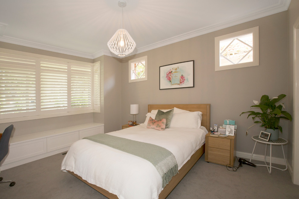 This is an example of a mid-sized contemporary bedroom in Melbourne with beige walls, carpet and no fireplace.