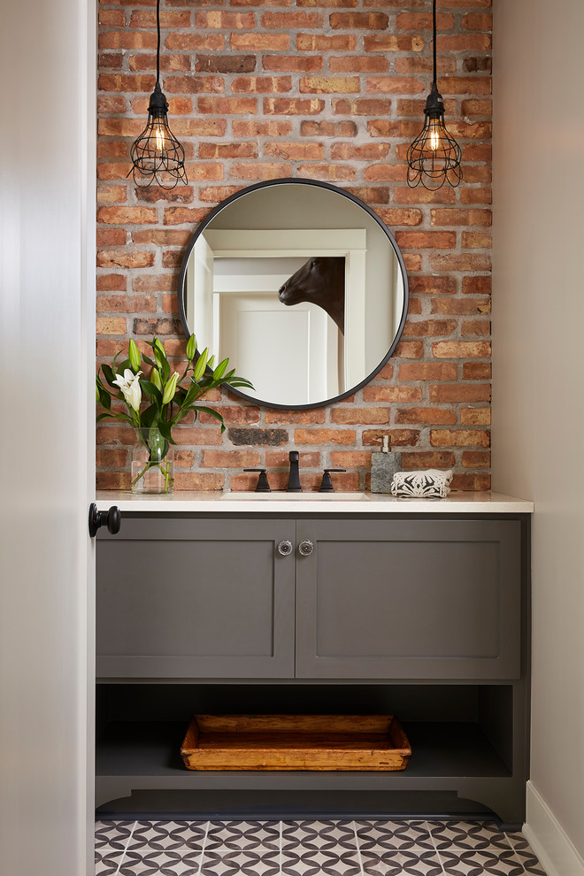 This is an example of a mid-sized industrial 3/4 bathroom in Minneapolis with furniture-like cabinets, grey cabinets, an alcove shower, a two-piece toilet, porcelain tile, grey walls, cement tiles, an undermount sink, engineered quartz benchtops, white floor, a hinged shower door and white benchtops.