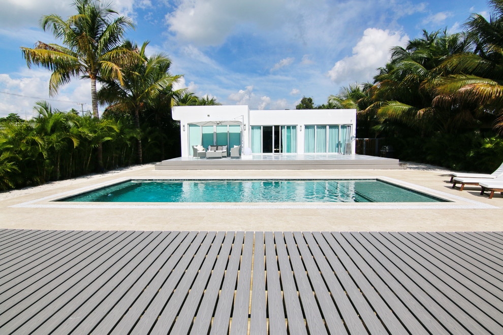 Diseño de piscina alargada moderna rectangular en patio trasero con entablado