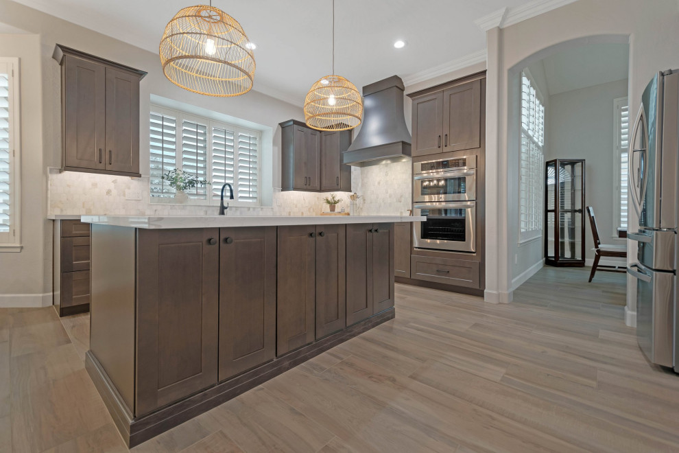 Example of a large porcelain tile and brown floor eat-in kitchen design in Phoenix with an undermount sink, shaker cabinets, quartz countertops, multicolored backsplash, marble backsplash, stainless steel appliances, an island and white countertops