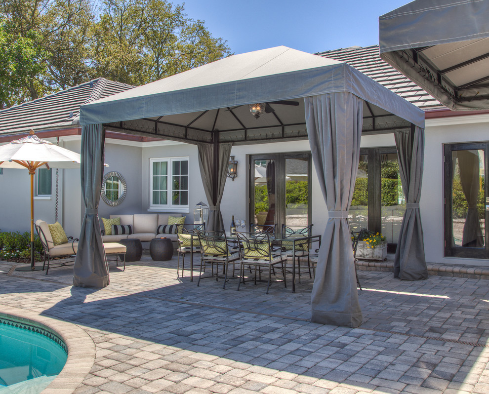 This is an example of a mid-sized traditional backyard patio in Tampa with brick pavers and a gazebo/cabana.