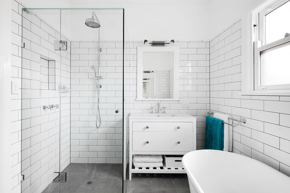 Design ideas for a transitional master bathroom in Melbourne with white cabinets, a curbless shower, white tile, subway tile, white walls, an undermount sink, grey floor, a hinged shower door, white benchtops and flat-panel cabinets.