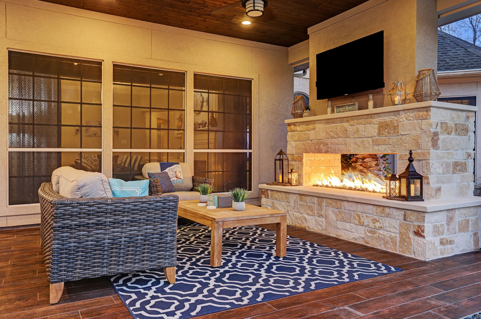 Design ideas for a mid-sized country backyard patio in Houston with with fireplace, tile and a roof extension.