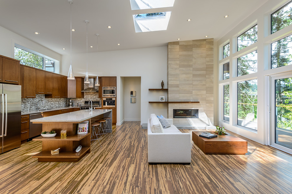 This is an example of a contemporary l-shaped open plan kitchen in Vancouver with flat-panel cabinets, dark wood cabinets, multi-coloured splashback, matchstick tile splashback and stainless steel appliances.