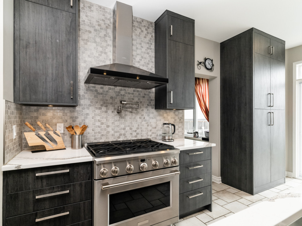 Photo of a contemporary kitchen in Ottawa with flat-panel cabinets, dark wood cabinets, quartz benchtops, white splashback, mosaic tile splashback, stainless steel appliances, with island and white benchtop.