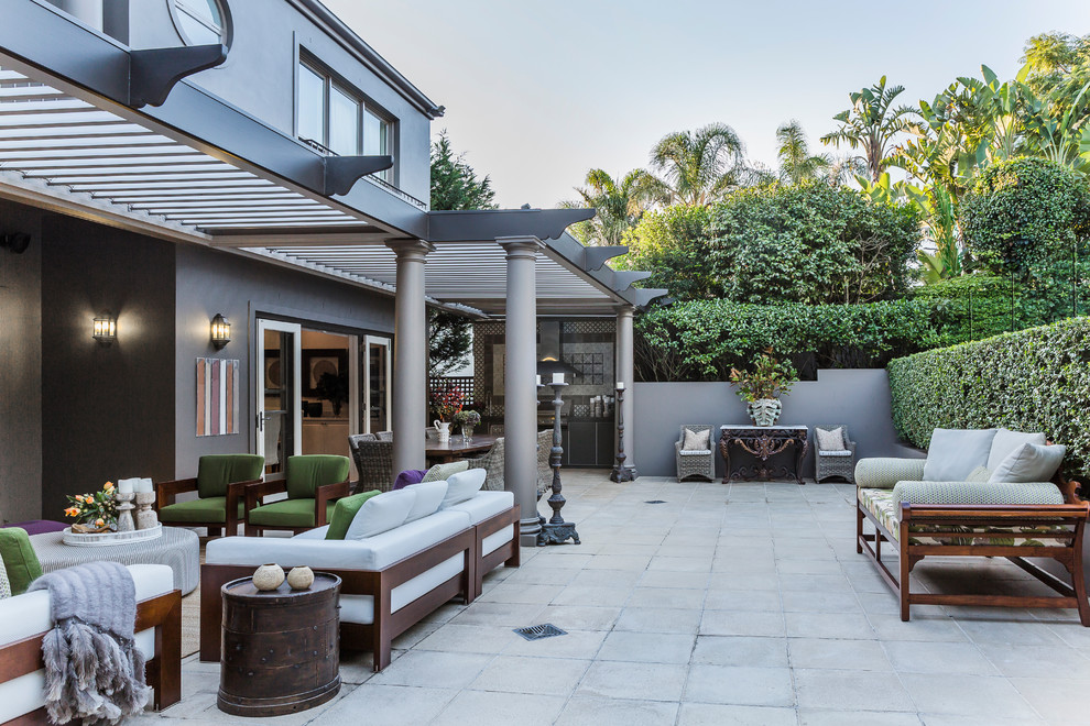 Inspiration for a large eclectic backyard patio in Sydney with an outdoor kitchen, natural stone pavers and a pergola.