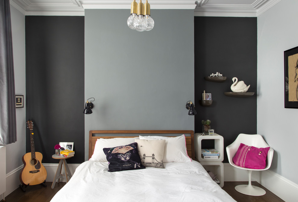 This is an example of a mid-sized contemporary bedroom in London with multi-coloured walls, dark hardwood floors and brown floor.