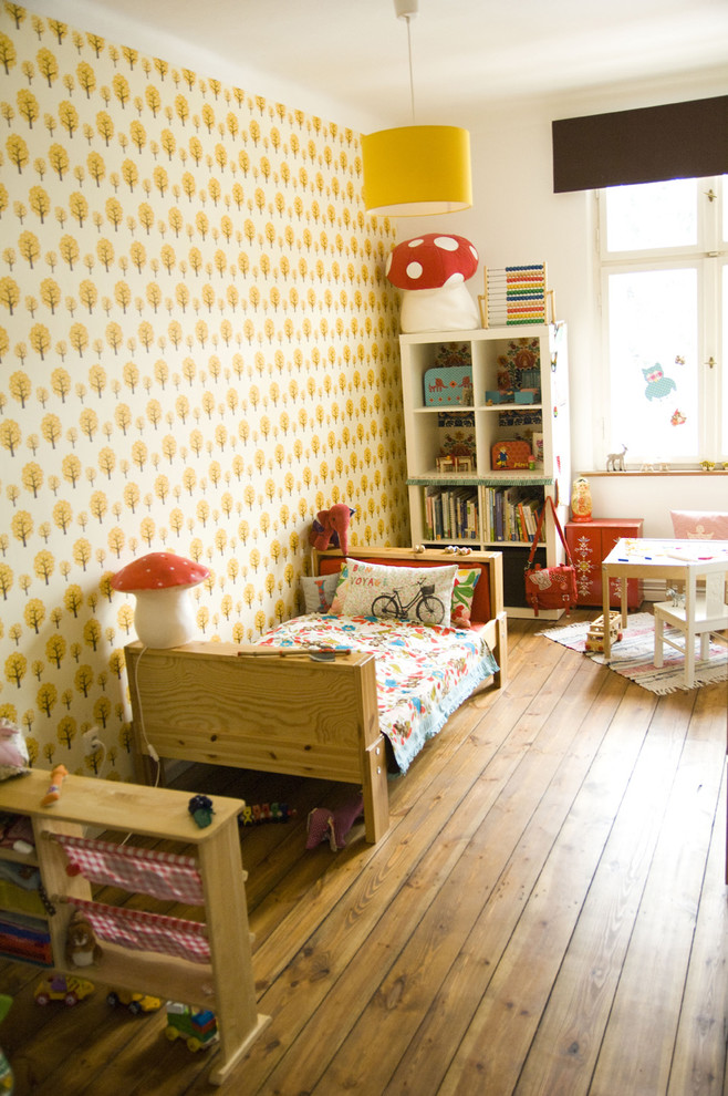 Inspiration for a large scandinavian gender-neutral kids' bedroom for kids 4-10 years old in Berlin with medium hardwood floors and multi-coloured walls.