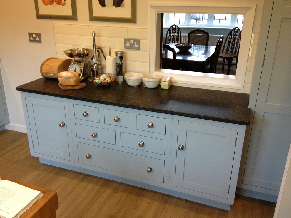 This is an example of a small traditional u-shaped separate kitchen in Cambridgeshire with a single-bowl sink, shaker cabinets, blue cabinets, granite benchtops, ceramic splashback, panelled appliances and linoleum floors.
