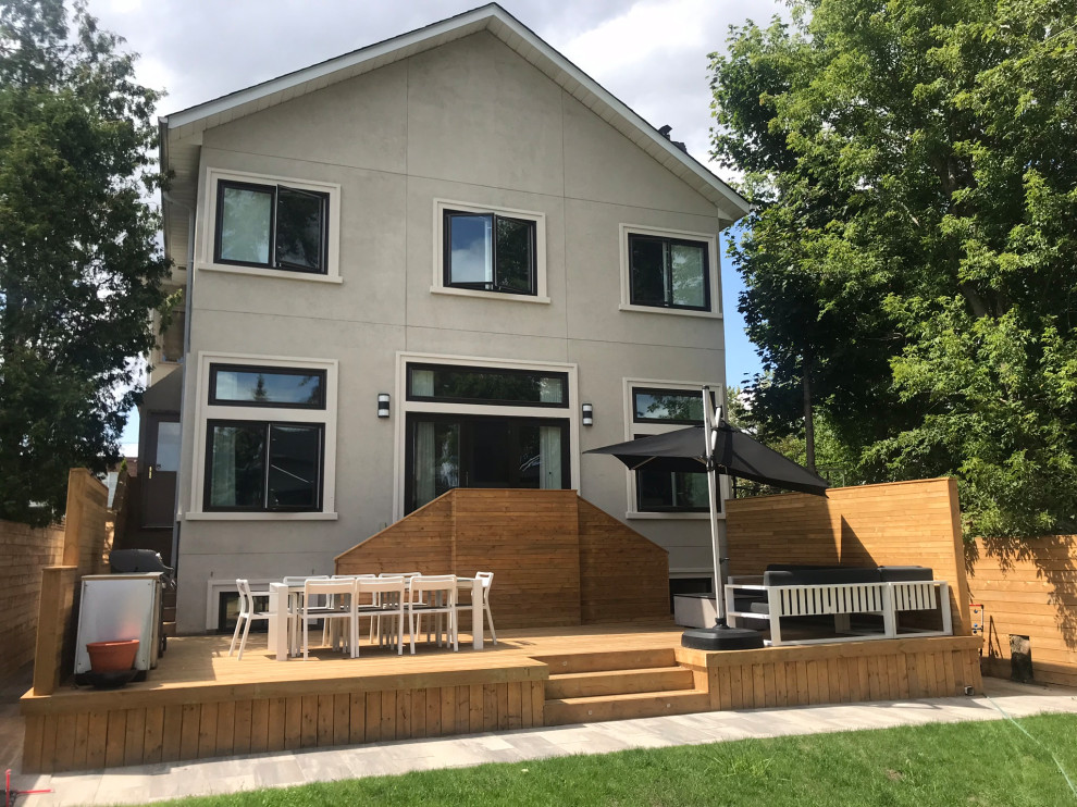 Deck - large backyard ground level wood railing deck idea in Toronto