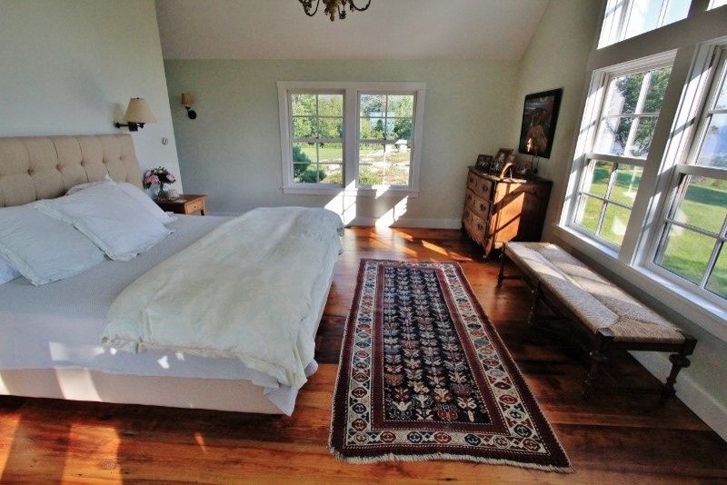 Design ideas for a traditional master bedroom in Burlington with white walls and medium hardwood floors.