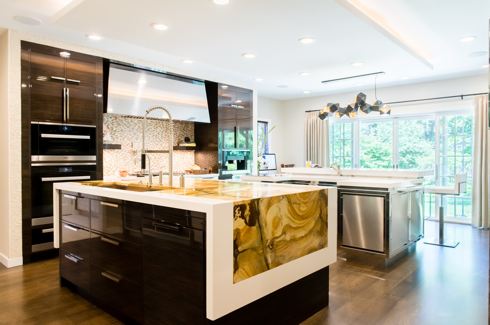 Large contemporary u-shaped eat-in kitchen in Cleveland with an undermount sink, flat-panel cabinets, stainless steel cabinets, quartzite benchtops, panelled appliances, medium hardwood floors, multiple islands, beige splashback, mosaic tile splashback and yellow benchtop.