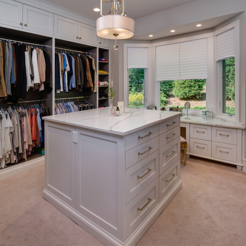 Design ideas for a large transitional gender-neutral walk-in wardrobe in Detroit with recessed-panel cabinets, white cabinets, carpet and beige floor.